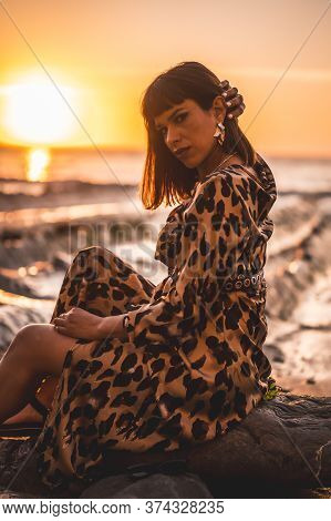 Summer Lifestyle On A Beach By The Rocks Of A Young Brunette Caucasian Woman By The Sea And Rocks. S