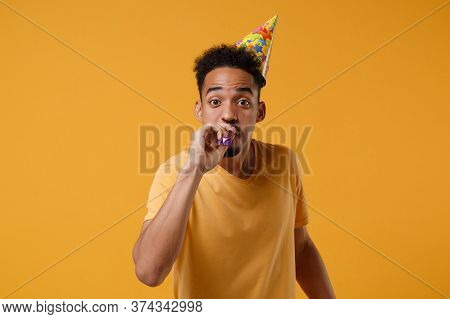 Funny Young African American Guy In Casual T-shirt, Birthday Hat Posing Isolated On Yellow Orange Wa