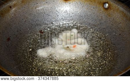 South Indian Cuisine - Vada Or Medu Vadai Frying In Coconut Oil. Raw Batter. Very Popular South Indi