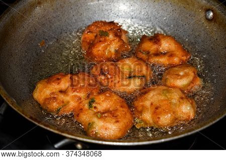 South Indian Cuisine - Vada Or Medu Vadai Frying In Coconut Oil. Very Popular South Indian Snack.