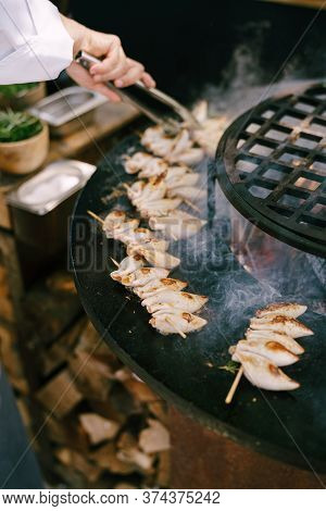 The Chef Grills The Squid On Wooden Skewers.