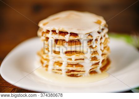 Condenced Milk Being Poured On A Stack Of Pancakes.