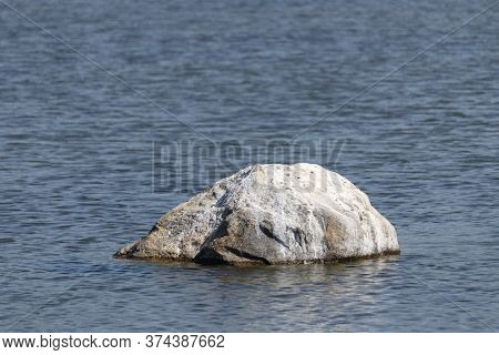 Small Boulder Protruding From Sea Water On The Gulf Of Riga