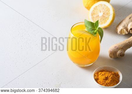 Jamu Indonesian Freshness Drink With Ice Cube, Turmeric, Ginger, Lemon On White Background. Close Up