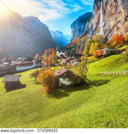 Gorgeous Autumn Landscape Of  Alpine Village Lauterbrunnen With Famous Church And Staubbach Waterfal