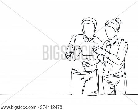 One Single Line Drawing Of Two Young Male And Female Workers Watching Stock Movements On Tablet Toge