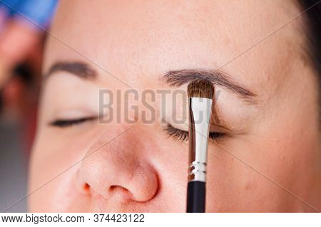 Face Painting. Makeup Artist Applying Make Up To Adult Model Eyes. Cosmetic Beauty Procedures, Makeu