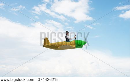 Happy Pilot Driving Small Propeller Plane On Background Of Blue Sky With Clouds. Traveling Around Th
