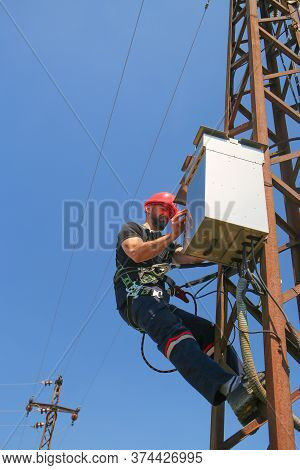 Tehnician In Red Helmet Working On Power Transmission Line