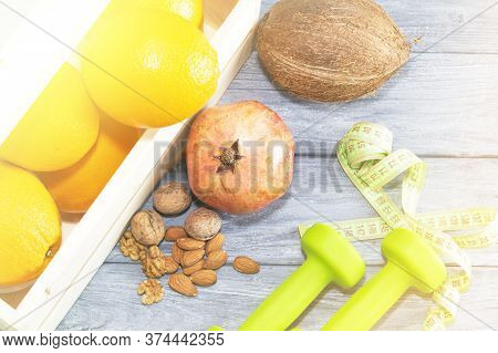 Lots Of Oranges, Dumbbells, Measuring Tape On A Wooden Textured Background. Fitness, Sports Nutritio