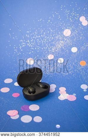 Ear Buds On Bright Classic Blue Background With Colorful Confeti And Sparklets. Festive Background.