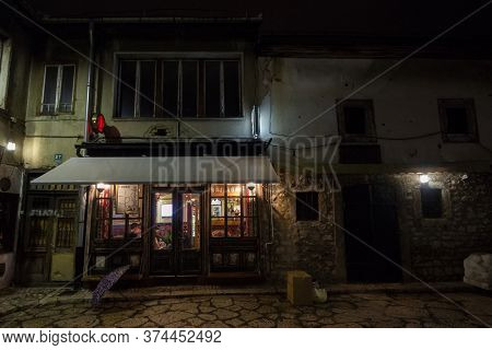 Sarajevo, Bosnia - April 15, 2017: Typical Cafe And Bar Of Bascarsija At Night With A Few People Rel