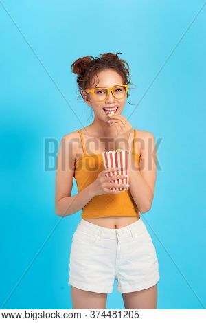 Beautiful  Girl Eat Popcorn And Watch Comedia Movie Isolated On Blue Background