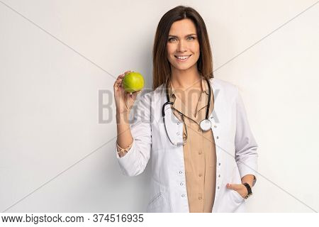 Medical Doctor Woman Smile With Stethoscope Hold Dreen Fresh Apple In Hand. Isolated Over White Back
