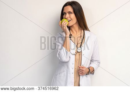Medical Doctor Woman Smile With Stethoscope Hold Dreen Fresh Apple In Hand. Isolated Over White Back