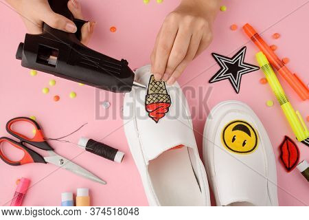 Girl Applying Patches To White Slip-on Shoes Using A Hot Glue Gun