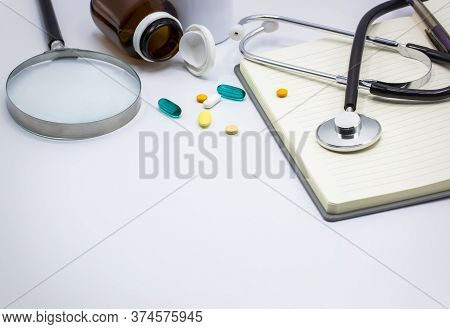 Medical Headphones With Medicine And Notebook Isolated On White Background, Magnifying Glass,copy Sp