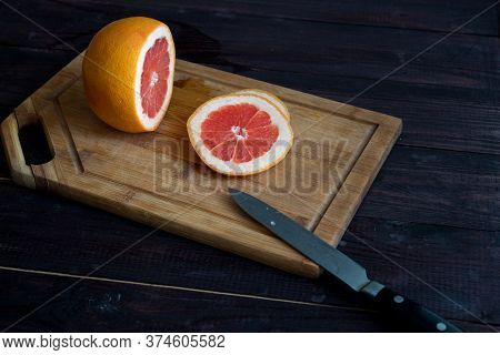Cut The Grapefruit On A Wooden Plate On A Wooden Table