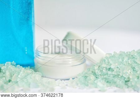 Blue Gel In A Bottle, White Cup, Blue Bath Salt, Cream In A Jar On A White Background.