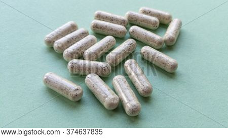 Pill Capsules With Dry Kelp On Mint Background. Simple Flat Lay With Pastel Texture. Medical Concept