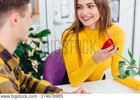 Cropped Shot Of Romantic Couple Having Romantic Dinner On Special Event. Focus On Violet Flowers On 