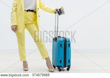 Cropped Shot Of Female Carrying A Suitcase And Passport Over White Background With Copyspace.
