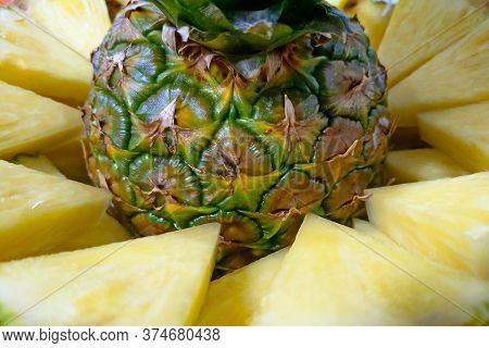 Jiucy Pineapple Slices Together With Pinapple On A Plate