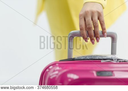 Cropped Shot Of Female Hand Carrying A Pink Suitcase Over White Background With Copyspace.