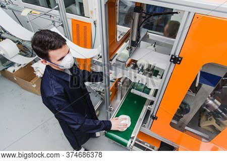 A Worker Stands At The Machine In A Factory For The Manufacture Of Medical Masks With Nanofiber. Cor