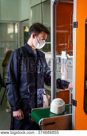 A Man Works At A Machine For The Manufacture Of Medical Masks With Nanofiber. Coronovirus And Covid-