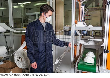 A Man Works At A Machine For The Manufacture Of Medical Masks With Nanofiber. Coronovirus And Covid-