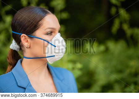 A Beautiful Woman Is Standing In The Street In A Medical Mask On Her Face Made Of Nanofiber. Coronav