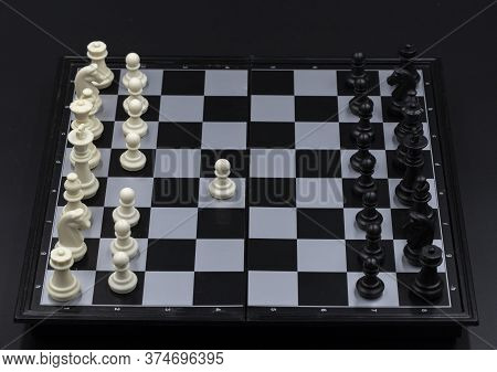 Chess Game Begin On Chessboard. Checked Board With Figure On Black Background. Chess Figurine Order.