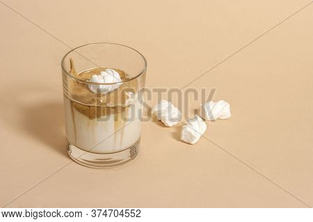 Dalgon Coffee In A Transparent Glass With Milk On A Pastel Background With Marshmallows.