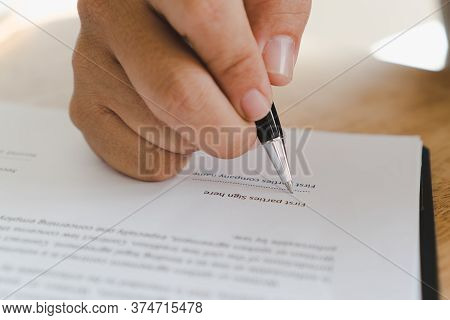 Person Is Signing His Name In Document.