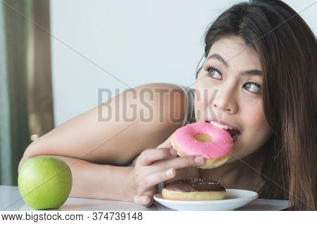 Girl On Dieting For Good Health And Good Shape Concept. Cheated Woman Sneak Eating Sweet During Diet