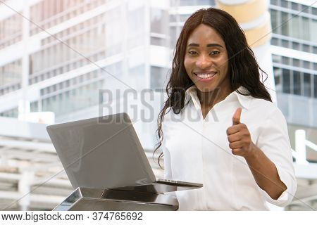 Young African Lady Showing Thumbs Up And Smile With Laptop Computer .