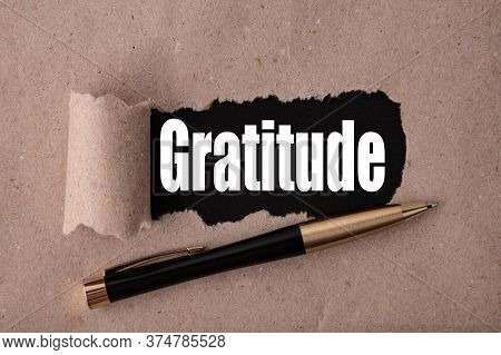 Gratitude Text Written Under Torn Paper And A Recumbent Metal Pen. Business Strategy Concepts.