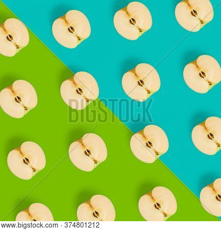 Creative layout over colorfool background. Fruit pattern. Apple halves geometrical layout. Flat lay, top view. Food background..  Pop art design, creative summer concept.