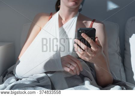 Wounded Arm In Bondage, Woman Rests In  Bed, Body Parts. Caucasian Female Adult In Bright Sun-lit Ro