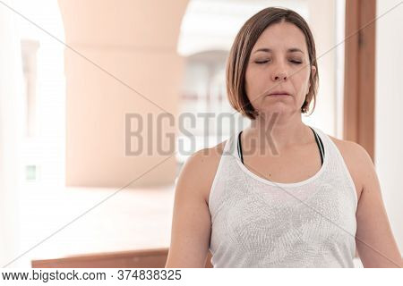 Woman Sitting In The Lotus Position With Their Eyes Closed Meditate In Silence. Yoga Teacher Sitting