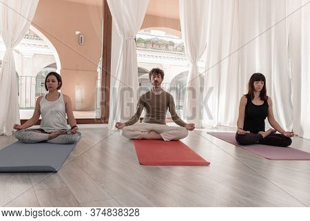 Yoga Teachers Sitting In The Lotus Position With Their Eyes Closed. Group Of People Practicing Yoga.