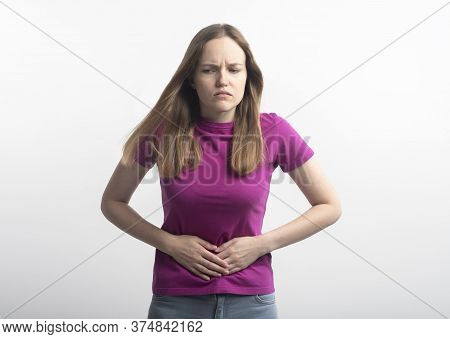Caucasian Young Woman In Violet T-shirt With Stomachache Putting Her Hands On Ab Squirming In Pain O
