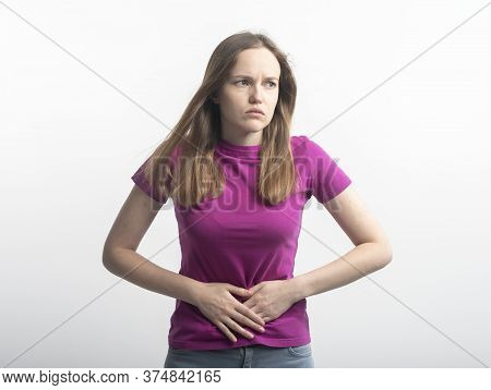 Caucasian Young Woman In Violet T-shirt With Stomachache Putting Her Hands On Ab Squirming In Pain O