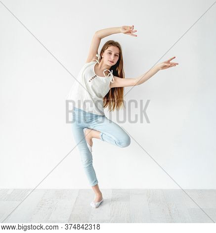 young girl dancing contemp on white wall background