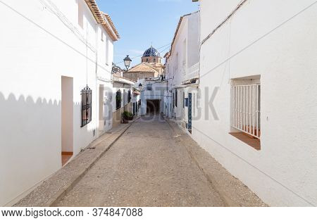 Narrow Medieval Cobbled Street To The Blue Domed Church In The Old Town Center Of Altea, Costa Blanc