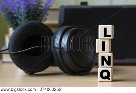 Linq -word On Cubes On The Background Of The Tablet, Headphones And A White Cup. Technology And Comp