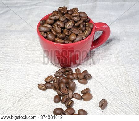 Red Ceramic Coffee Mug Filled With Coffeebeans