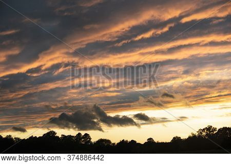 Beautiful Summer Sunset Sky With Colorful Vibrant Clouds And Sun Beams Across Whole Sky