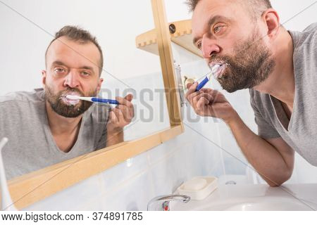 Funnny Guy Taking Care Of His Oral Hygiene, Brushing Teeth During Morning Bathroom Routine.